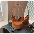 Dettaglio borsa a secchiello in finta pelle scamosciata marrone con logo oro e charm su libri - Con Ciondolo / Marrone