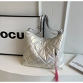 Close-up of quilted silver puffer bag with metallic finish and pink tassel charm detail - Off-white