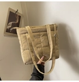 Detalle del bolso acolchado beige mostrando la textura de nailon y cierre de cremallera - Caqui