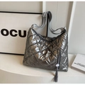 Detail of silver metallic quilted tote with woven shoulder strap and long tassel decoration - Silver