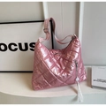 Detailed view of pink quilted tote bag with silver tassel and striped shoulder strap - Pink