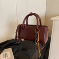 Bordeaux red glossy crossbody bag with woven rope charms and golden metal hardware - Wine Red With Pendant