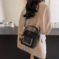 Sac seau noir avec large bandoulière tissée et breloque lapin porté par le mannequin - Noir avec pendentif