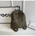 Detail of olive green quilted backpack featuring metallic zippers and soft padded texture - Green
