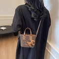 Sac seau léopard avec bordure en cuir marron présenté dans une vue latérale élégante - Café (Avec Pendentif)