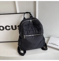 Detail of a black quilted backpack featuring high-quality silver zippers and smooth texture - Black