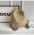 Detail of beige puffer backpack featuring horizontal quilting and silver metal zippers - Khaki