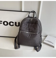 Close-up of dark grey quilted backpack on display with silver zippers and side pockets - Gray