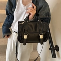 Vintage Damen-Umhängetasche aus schwarzem Lackleder, getragen von einem Modell - Schwarz