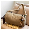 Détail d'un sac matelassé kaki avec breloque lapin en peluche sur un canapé beige - Khaki avec Pendentif