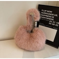 Close-up of fluffy pink faux fur handbag featuring elegant silver heart-shaped metal charms - Pink