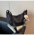 Close-up of black quilted nylon moon bag with adjustable strap and cat charm accessory - Black (with Pendant)