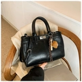 Sac Kelly classique en similicuir brillant noir avec un charmant accessoire fraise - Noir avec pendentif