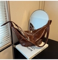 Detail of the high-gloss brown leather croissant bag with wide shoulder strap - Brown