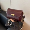 Chic burgundy faux leather crossbody bag with wide patterned strap and gold buckle - Burgundy