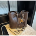 Detail view of brown matte leather tote bag with creative baseball glove charm on side - With Charm / Coffee