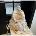 Dettaglio zaino in nylon crema con tasche a coulisse e tiretti della zip in corda intrecciata - Bianco Sporco