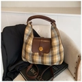 Dettaglio borsa hobo scozzese autunnale con manico in pelle su poltrona in tessuto - Marrone a Quadri
