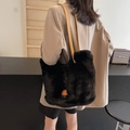 Borsa tote in ecopelliccia nera con spalline in pelle marrone indossata da modella - Nero