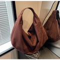 Macro shot of dark caramel suede tote bag detail with premium matte texture and zipper - Red Brown