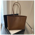 Detailed close-up of a large brown leather tote bag with elegant stitching and slim straps - Brown