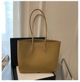 Detail of light brown leather tote bag showing fine stitching and smooth texture - Khaki