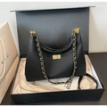 Detail of black pleated leather bag with gold clasp and chain strap in gift box - Black