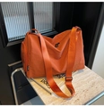 Detalle del bolso tote naranja de gran capacidad con logo sobre fondo de mármol - Naranja