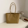 Bolso tote grande minimalista en cuero sintético color camel en una acogedora escena interior - Caqui