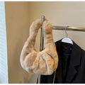 Detail of beige faux fur handbag with golden chain strap on clothing rack - Khaki