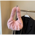 Close-up of pink faux fur texture and metal chain strap on a plush crossbody bag - Pink