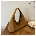 Dettaglio ravvicinato della borsa hobo in pelle scamosciata marrone su tavolo rustico - Marrone