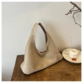 Dettaglio di borsa scamosciata beige su tavolo in legno con decorazioni - Bianco Sporco