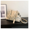 Primer plano del bolso tote de cuero sintético crema con anillos de metal y bandolera - Gris