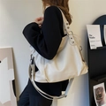 Große beige Eimer-Einkaufstasche aus PU-Leder mit breitem Gurt und Metallnieten - Weiß