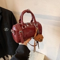 Dunkelrote glänzende Zylindertasche mit Bärenanhänger von einem Model getragen - Weinrot (Mit Anhänger)
