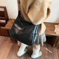 Grande borsa a tracolla nera in pelle vintage indossata da una modella per ufficio - Nero