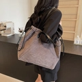 Sac cabas en velours côtelé marron avec anses en cuir noir porté par un mannequin - Gris