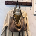 Dark brown retro hobo bag in faux leather with shoulder strap shown on a beige coat - No Pendant / Khaki
