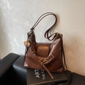 Bolso tote vintage de cuero marrón oscuro con colgante de béisbol en sofá - Con Colgante / Marrón Oscuro