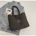 Detail of large charcoal grey canvas tote bag styled with denim and casual lifestyle props - Dark Brown