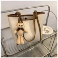 Detalle de bolso tote bicolor con textura suave y accesorio de llavero de oso tejido - Combinación de Bolso Y Bolsa / Blanco