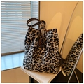 Large leopard print bucket bag with handmade metal plate on a stylish white book - Brown