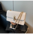Detail of white faux leather bag featuring a gold twist lock and fine metal chain strap - White