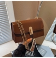 Detail of deep brown crossbody bag with gold chain strap and accordion side design - Brown