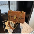 Close-up of vintage brown quilted leather bag with brass turn-lock and gold chain strap - Brown