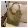 Bolso tote de tejido artesanal verde oliva sobre un sofá beige en un entorno minimalista - Verde