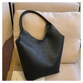 Détail du sac hobo en cuir tressé noir de haute qualité sur une chaise en tissu - Noir