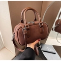 Nahaufnahme braune Wildleder-Bostontasche mit Ledergriffen und silbernen Metallteilen - Braun