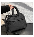 Detail shot of black quilted puffer handbag with soft texture and adjustable straps - Black